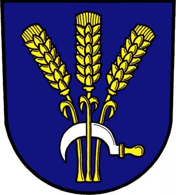 V modrém štítě tři, krajní odvrácené, zlaté obilné klasy, dole proložené položeným stříbrným srpem se zlatou rukojetí. Znak Čaková