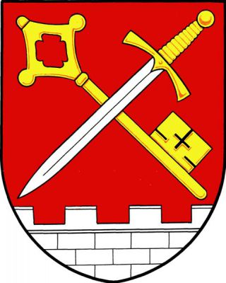 V dolní části červeného štítu stříbrná kvádrová hradba s cimbuřím, nad ní kosmo položený zlatý klíč křížem přeložený stříbrným mečem, hrotem dolů, se zlatým jílcem a záštitou. Znak Kostelec u Holešova