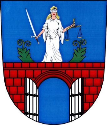 V modrém štítě červená kvádrovaná zeď s prázdnou branou a stříbrnými vraty na černých závěsech. Na hradbě stojí stříbrná postava Spravedlnosti se stříbrným mečem v pravé a zlatými miskovými vahami v levé ruce, provázená dvěma vyrůstajícími zelenými ratolestmi. Znak Křinec
