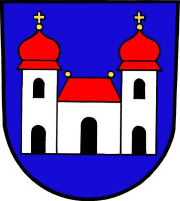 V modrém štítě stříbrná budova s prolomenou černou branou a červenou valbovou střechou se dvěma zlatými makovicemi. K budově přiléhají dvě stříbrné věže, každá s prolomenou černou branou, černým obloukovým oknem a červenou bání se zlatou makovicí s křížkem. Znak Machov