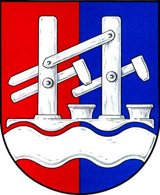 V červeno-modře polceném štítě dva buchary hamru nad vlnitým břevnem, vše stříbrné. Znak Nové Hamry
