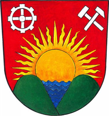 V červeném štítě nad dvěma zelenými vrchy spojenými modrou hladinou zlaté vycházející slunce provázené nahoře palečným kolem a hornickými kladívky, oboje stříbrné. Znak Nový Jáchymov