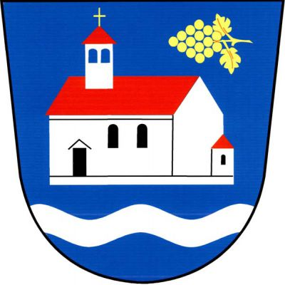 V modrém štítě nad stříbrným vlnitým břevnem stříbrný kostel s věží, červenými střechami, černými okny a dveřmi. Kostel je provázený vlevo nahoře položeným zlatým vinným hroznem se dvěma listy. Znak Přibice