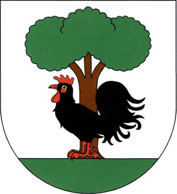Ve stříbrném štítě na zeleném trávníku černý kohout s červenou zbrojí, za ním listnatý strom přirozené barvy. Znak Staré Ždánice