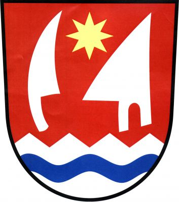 V červeném štítě nad stříbrnou pilovitou patou s modrým vlnitým břevnem přivrácené krojidlo a radlice, obojí stříbrné, vztyčené. Mezi nimi nahoře zlatá osmihrotá hvězda. Znak Stavenice