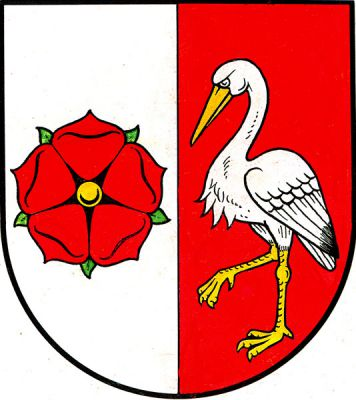 Stříbrno-červeně polcený štít. Vpravo červená růže se zlatým semeníkem a zelenými lístky, vlevo stříbrný čáp se zlatou zbrojí. Znak Včelnička