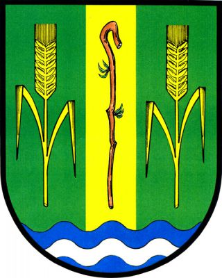 V zeleném štítě s modrou vlnitou patou se stříbrným vlnitým břevnem zlatý kůl s pastýřskou holí přirozené barvy, provázený dvěma zlatými obilnými klasy se dvěma listy. Znak Velenice