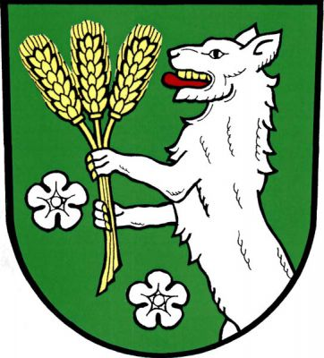 V zeleném štítě stříbrný vyskakující vlk se zlatou zbrojí a červeným jazykem držící tři zlaté obilné klasy, provázené vpravo a dole dvěma stříbrnými květy. Znak Vlčice