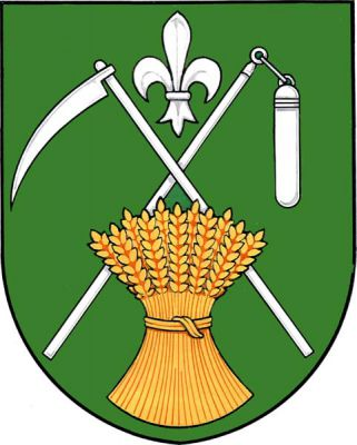 V zeleném štítě zkřížená kosa a cep, obojí stříbrné, v dolní části přes ně položený zlatý obilný snop, v horní části stříbrná lilie. Znak Zahnašovice